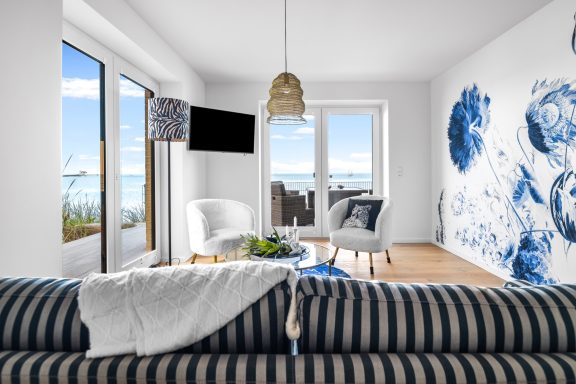 Wohnbereich mit Kamin Wohnbereich mit Sitzgruppe und bodentiefen Fenstern zur Terrasse und Ostseeblick - Blue Sea