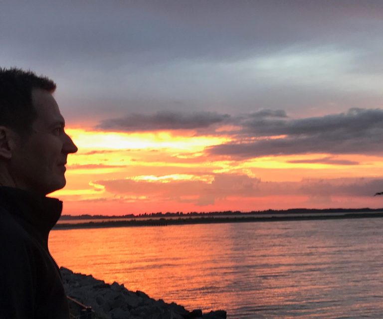 Privater Gastgeber Bent Lüngen vorm Sonnenuntergang über der Ostsee vor den Blue Ferienunterkünften