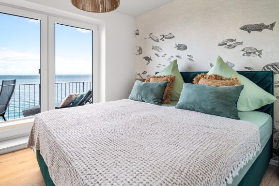 Meerblick-Schlafzimmer mit Doppelbett und Zugang zum Balkon - Blue Paradise.