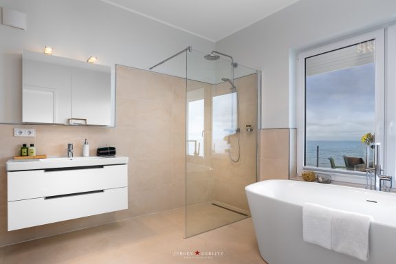 Große Badewanne vor dem Fenster zum Meer 