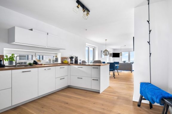 Offener Wohnbereich mit Meerblick Offener Wohnbereich mit Küche, Essgruppe und Sitzmöbeln und TV - Blue Sea