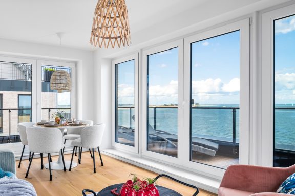 Gemütliche Sitzecke Runder Esstisch mit vier Stühlen vor bodentiefen Fenstern und Zugang zum Balkon - Blue Sky