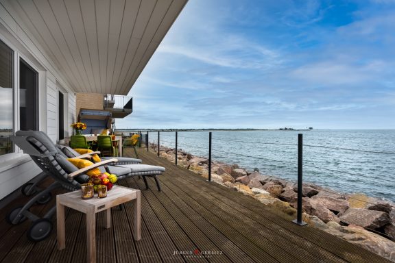 Terrasse direkt am Wasser mit Outdoormöbeln und Blick zur Schleimündung - Villa Blue Horizon