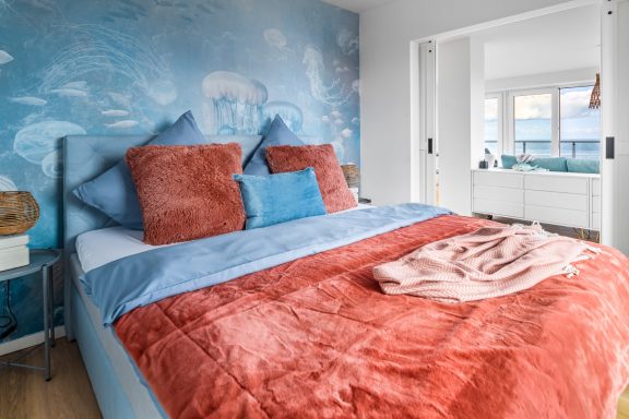 Super cosy! Maritimes Schlafzimmer mit Schiebetüren und Doppelbett, seitlich die Ostsee im Blick - Blue Sky