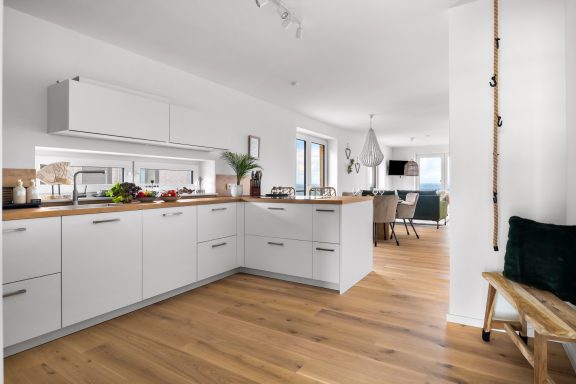 Offener Wohnbereich mit Küche, Essecke und Sofaecke mit TV