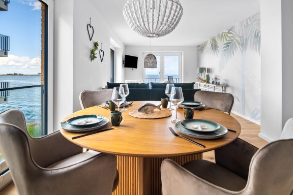 Esstisch mit Stühlen vor bodentiefem Fenster - Blue Paradise.